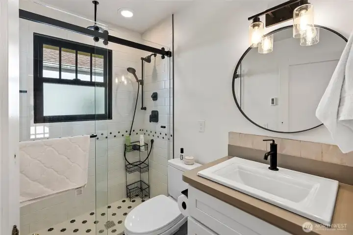 The bathroom has been completely redone with new lighting, glass shower, tile work, window, vanity and sink, fixtures, and new Toto toilet.