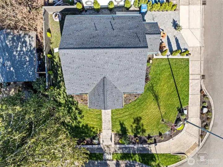 Drone view of the home with new roof and beautiful yard, all on a corner lot.