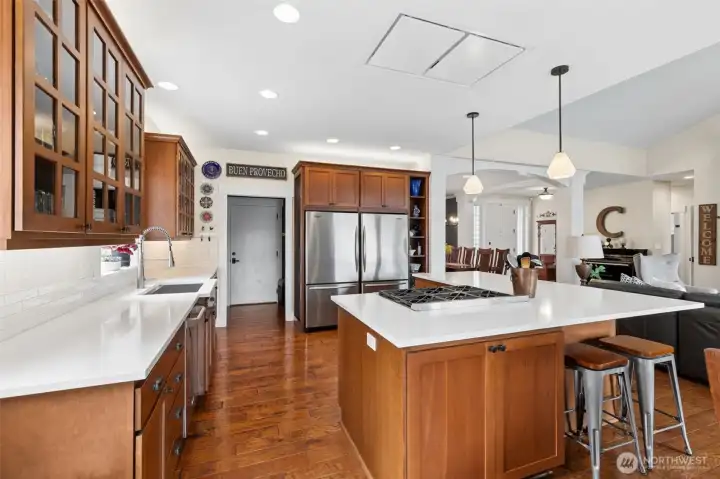 The island cooktop anchors the space, giving you a natural gathering point while still leaving room for multiple people to cook, prep, or just hover with a glass of wine. The dual refrigerator/freezer units come into full view here, which is a game changer for entertaining or just not having to play fridge Tetris. And then there’s the pantry beyond, not your average closet situation, but a full extension of the kitchen with its own oven, microwave, and storage that keeps everything running smoothly behind the scenes.