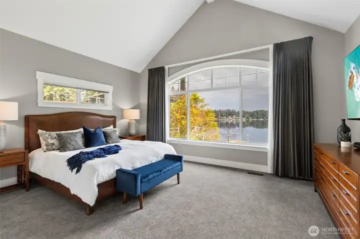 The arched window draws your eye straight to the water, giving the room a focal point that’s hard to compete with. Vaulted ceilings add height and airiness, while the second window keeps the light moving through the space. And then there’s the scale, this isn’t just a place for a bed. There’s room here for a sitting area, additional furniture, or even a quiet work zone without feeling crowded. A comfortable, open, and quietly impressive primary suite to make every day feel like a vacation.