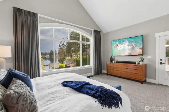 The lake view holds strong from here, and just to the side, that private door out to the deck makes it all feel a little more indulgent. Morning coffee, evening soak in the hot tub, no hallway required. The plush carpet underfoot adds to the comfort, giving the room that soft, relaxed feel that makes you want to linger a little longer. It’s the kind of space that leans into the idea of everyday luxury.