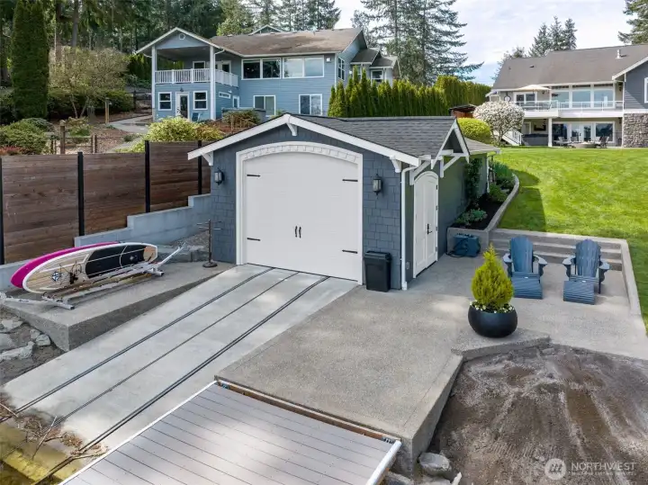The concrete walkway runs clean and level right out to the dock, no awkward steps, no balancing act, just a smooth, accessible path from lawn to water. There’s a great seating area tucked next to the boathouse, perfect for hanging out while everything else is in motion. The carriage-style detailing on the boathouse doors adds just the right amount of character without feeling overdone. And while you don’t see them here, there are three Rubbermaid sheds included with the property, giving you even more storage for all the extras that come with lake life.