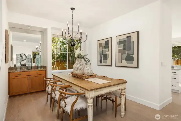 Elegant formal dining room highlighted by a statement chandelier and a built-in cherry wood bar with granite countertops—perfect for sophisticated entertaining.