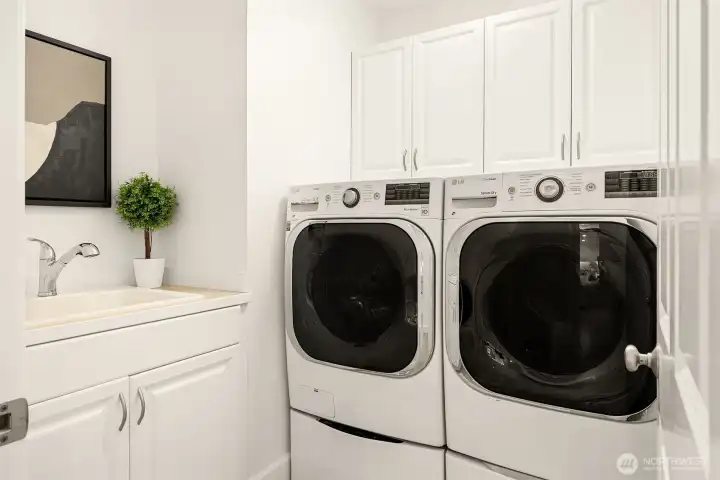 Highly functional laundry room with side-by-side washer/dryer, mini washer, utility sink, and abundant storage for everyday convenience