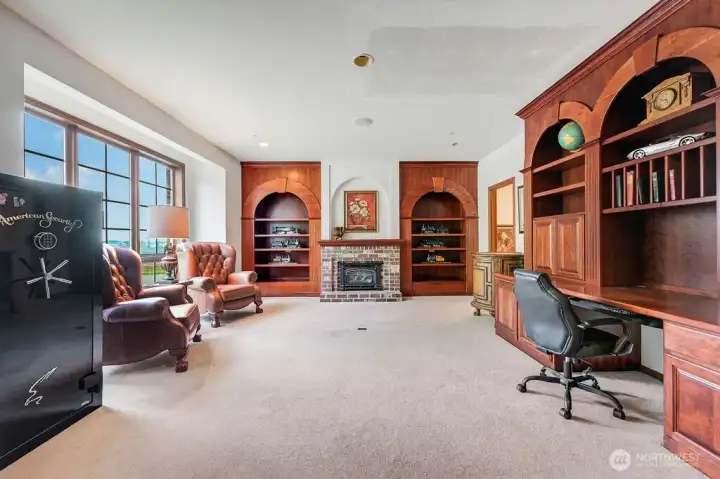 Den with 2 custom desks, cabinets and propane fire place. Plumbed for wet bar.