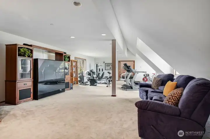 Room over garage currently used as a media room and home gym.
