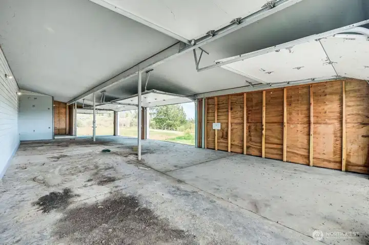 Garage area with 4 roll up garage doors. This room has had the personal items virtually remove.