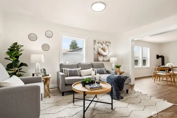 The living room offers a warm, inviting space where natural light and new LVP flooring highlight the home’s blend of vintage charm and modern updates. The living room offers a warm, inviting space where natural light and new LVP flooring highlight the home’s blend of vintage charm and modern updates.