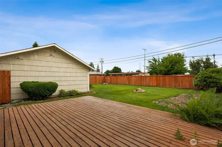 A spacious deck overlooks a fully fenced backyard, offering an ideal setup for outdoor dining, lounging, and gatherings. Garden space and a cozy fire pit round out this inviting retreat, room to relax and enjoy the seasons. A spacious deck overlooks a fully fenced backyard, offering an ideal setup for outdoor dining, lounging, and gatherings. Garden space and a cozy fire pit round out this inviting retreat, room to relax and enjoy the seasons.
