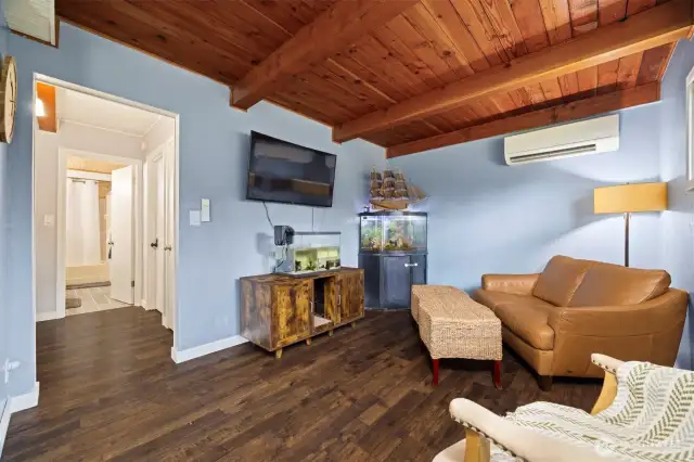 Another view of the family room with the hallway that leads to a main floor bedroom and a full bath.