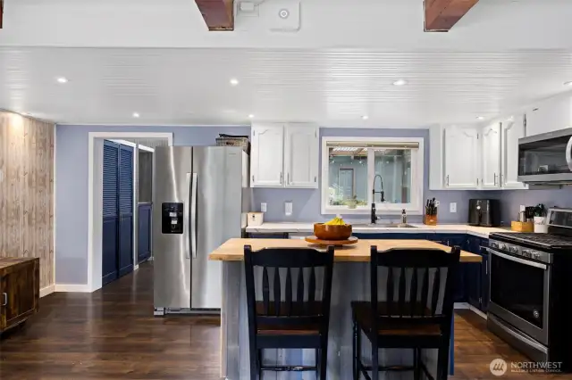 The kitchen is open and the stainless appliances are just 6 years old, or less. The kitchen looks out toward the swimming pool and has a 2-seat eating bar with lots of storage. There is also pantry space in the back porch/laundry room beyond.