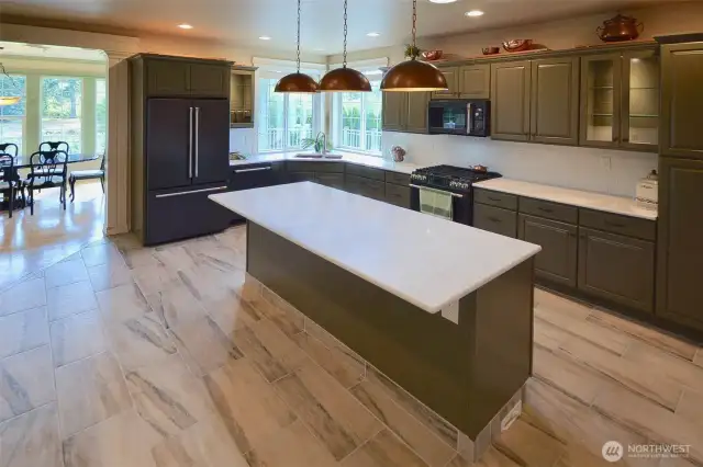 Every detail has been thoughtfully planned in this fabulous kitchen. Three custom copper lights illuminate the impressive quartz island. There's a unique hammered copper kitchen sink and recessed lighting under the cabinetry. The kitchen is equipped with two ovens (gas and electric) for big gatherings and special events.