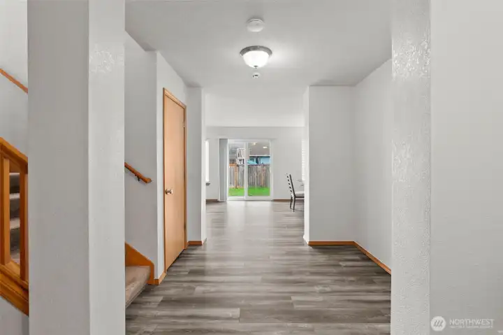 New floors greet you in a welcoming hallway. The door in the left center of the photo is a large understair closet. Lots of room for storage there.