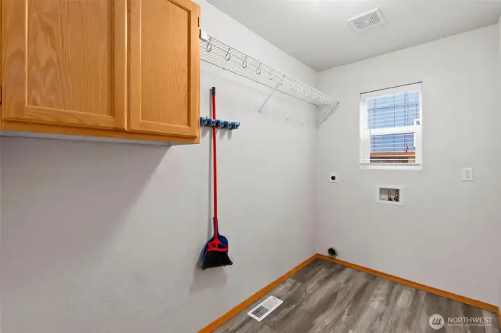 The laundry room features cabinets and a hanging rack, and lots of space.