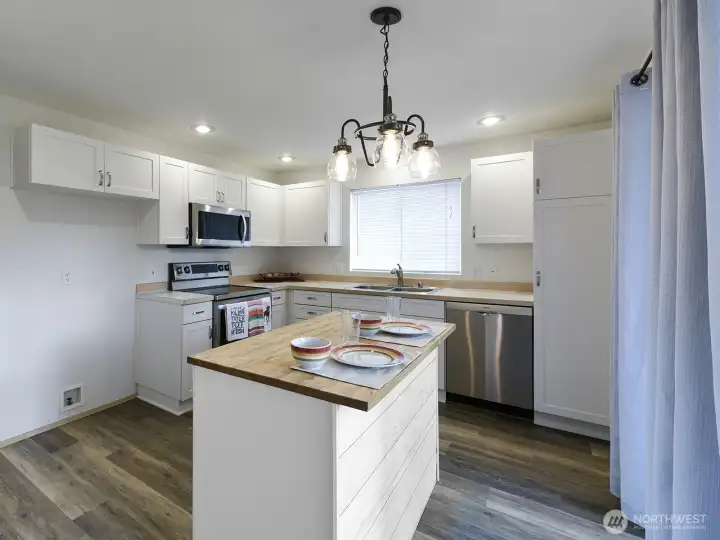 Tons of natural light floods this kitchen.  Island is custom built and can be moved.  What versatility!  Easy access to backyard patio with slider access on right.