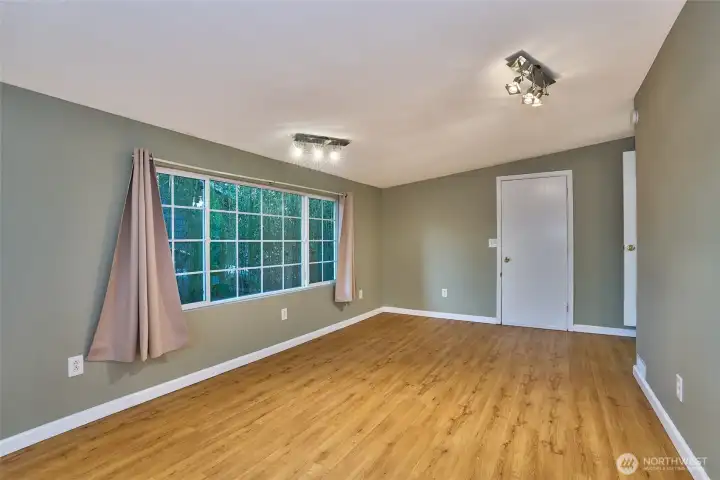 Another View of the Converted Garage into a Bedroom with Laminate Flooring and Newer Light Fixtures.