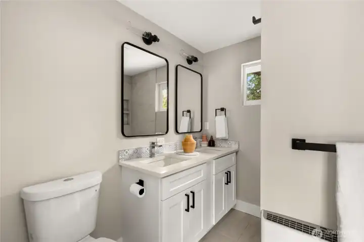Primary bathroom with custom vanity, dual sinks, Quartz counters and luxury Italian tile floor and shower.