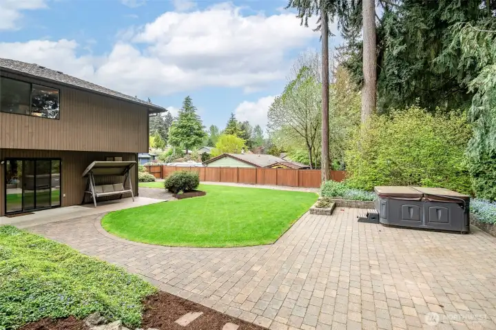 Back yard with beautiful pavers to the hot tub.