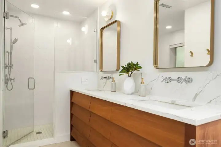 Primary full bathroom with heated floor, custom teak vanity, double sinks, standalone shower bench and glass enclosure as well as large bathtub Primary full bathroom with heated floor, custom teak vanity, double sinks, standalone shower bench and glass enclosure as well as large bathtub