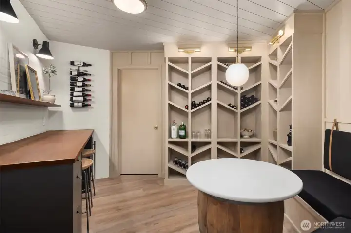 Wine room with teak countertop, built-in seating, built-in wine storage, wine fridge and wine barrel with solid white round tabletop Wine room with teak countertop, built-in seating, built-in wine storage, wine fridge and wine barrel with solid white round tabletop