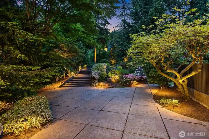 Evening view of courtyard with landscape lighting and stairs to circular drive Evening view of courtyard with landscape lighting and stairs to circular drive