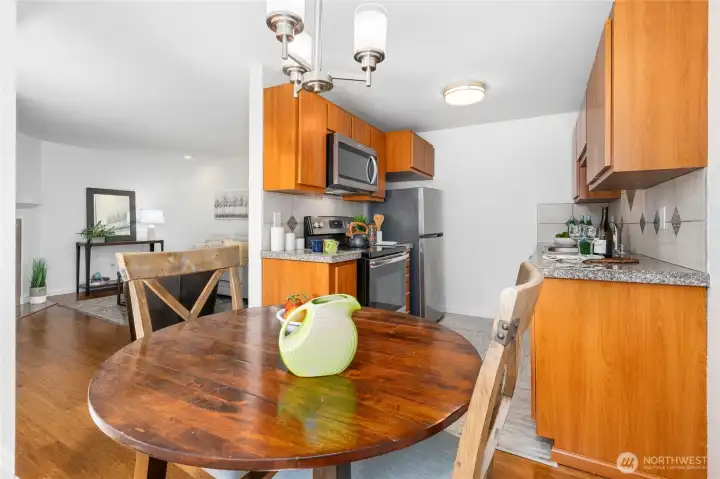 Warm wood plank floors through dining, living, entryway.