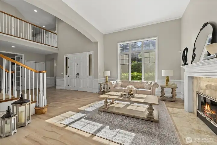 Formal living room with cozy fireplace and staircase
