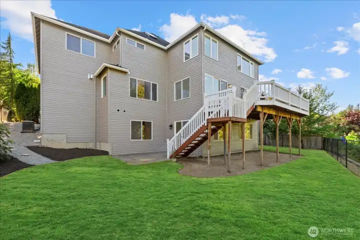Rear exterior showcasing the home and spacious backyard