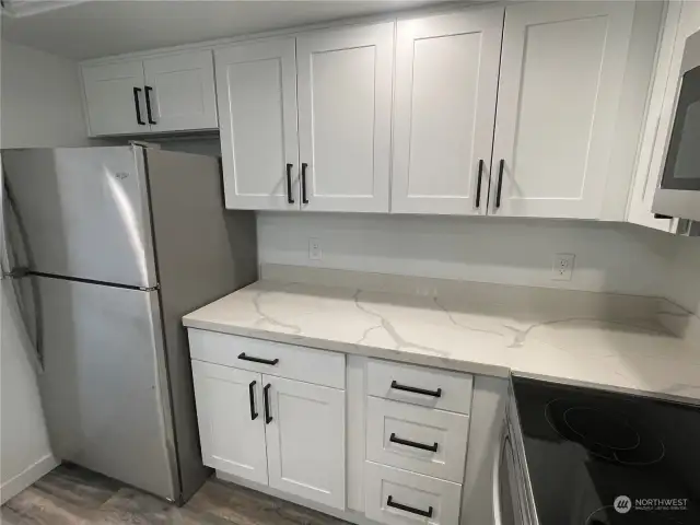 Look at all this additional counter space! There’s plenty of room to work, whether you're prepping meals or hosting guests. Plus, the newer stainless steel refrigerator adds a sleek, modern touch to the kitchen.