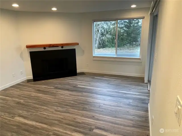 Another nod to the modern farmhouse vibe is the black fireplace surround, complemented by a single stained wood mantel, adding a warm and stylish focal point to the living area.