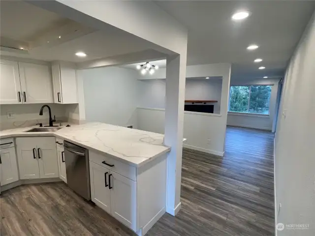 The unit features newer luxury vinyl flooring throughout, beautifully inspired by warm hardwood for a cozy, elegant feel. The sleek, low-maintenance slab Carrera marble-inspired quartz countertops add a touch of style and sophistication to the space.