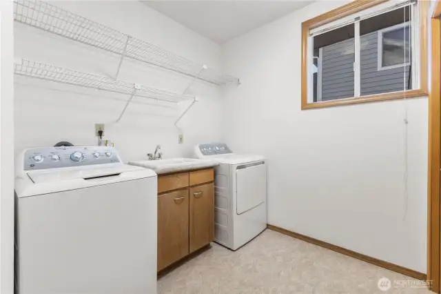 Laundry room features a utility sink and large linen/coat closet.