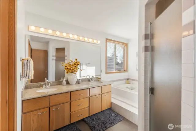 Double sinks and private water closet in bathroom suite.