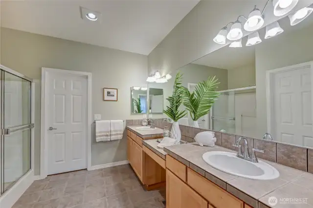 Primary bathroom with dual sinks, a step-in shower, walk-in closet and private water closet.