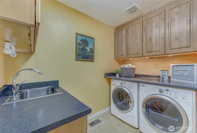 Terrific laundry room with full size washer and dryer, folding counter, lots of storage and a handy sink.