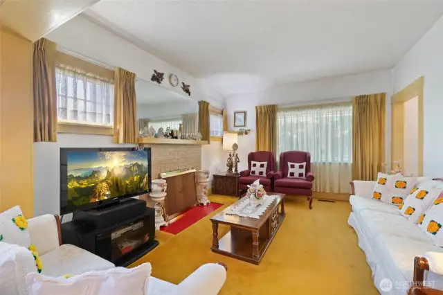 Wood burning fireplace in living room, with plenty of space and natural light.