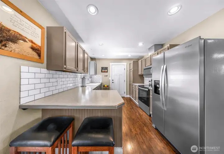 Galley kitchen offers abundant cabinet storage, generous counter space, and a breakfast bar for casual dining Galley kitchen offers abundant cabinet storage, generous counter space, and a breakfast bar for casual dining