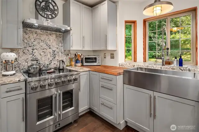 Custom tile work on the wall behind the Forno stove with french doors and enamel interior.