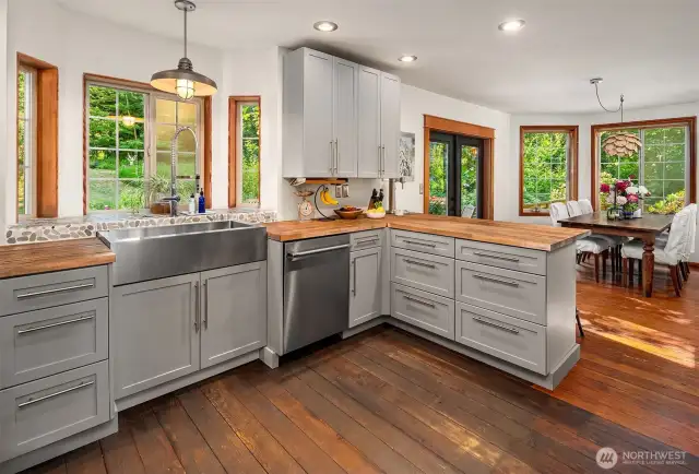 Great tile work and stainless steel farm sink. Eating bar and light-filled dining area with French doors.