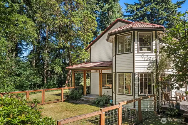 So many outdoor spaces to enjoy -- this one is perfect for keeping littles or pets safe while outside. Here you can also see the way the windows embrace the dining area and the primary suite.