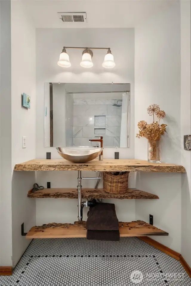 Completely renovated  spa-like bath with marble tiled shower, custom shelving.