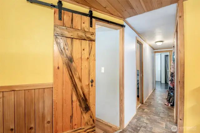 View Down The Hallway To Primary, Starting At Bedroom 3 W/ a Barn Door
