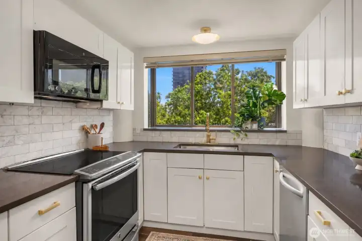 Light-filled, updated kitchen with beautiful views of trees and sky