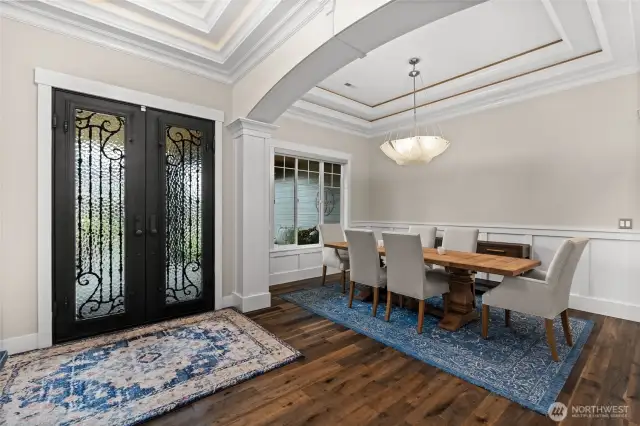 A stunning grand entry showcases coffered ceilings, elegant French doors, and exquisite millwork, all beautifully accented by recessed lighting.
