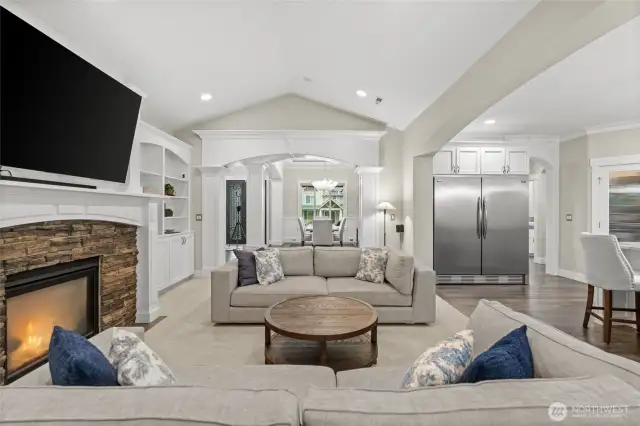 The vaulted ceiling in the great room enhances the sense of space, creating a visually striking setting with seamless flow to the exquisite millwork and graceful arched doorways.