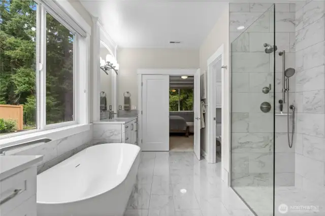 A walk in frameless glass shower is highlighted by floor to ceiling tiling and brushed nickel shower hardware.