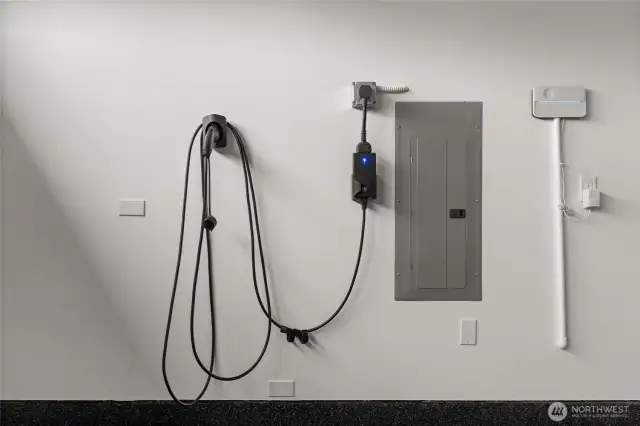 The three-car garage is upgraded with an electric vehicle charging port and also features a tankless water heater, ceiling storage racks, and built-in cabinetry for maximum functionality.