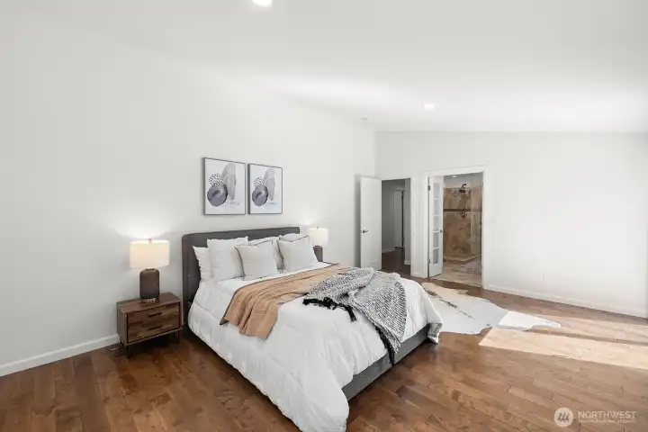Spacious primary bedroom with vaulted ceilings and a private bathroom.