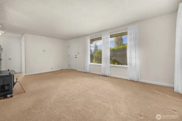 View from dining area of front entry & living room.  Living room has large picture windows providing plenty of natural light.