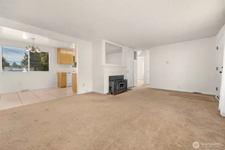 View from NW corner of living room showing dining area, fireplace insert & hallway to full bathroom & bedrooms 1 & 2.